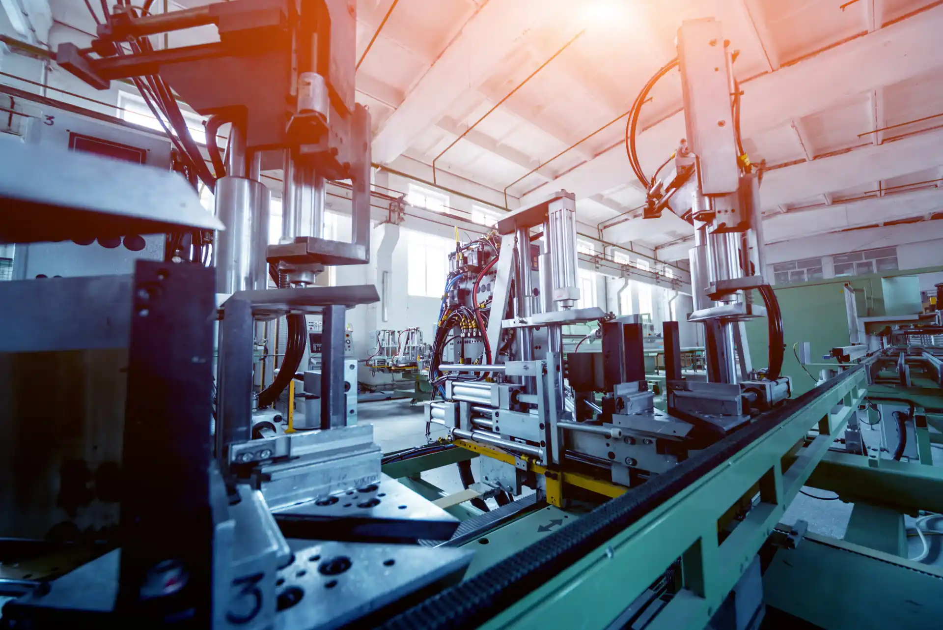 Industrielle Fertigungsanlage zur Herstellung von Fenstern und Türen aus Aluminium und PVC – Detailaufnahme von Maschinen und automatisierten Produktionslinien in einer modernen Fabrikhalle.