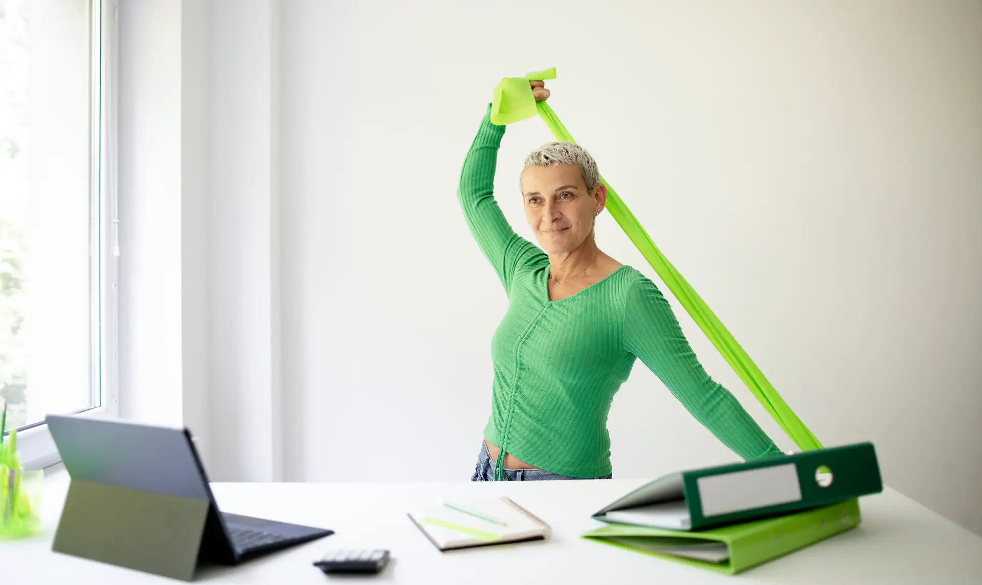 Mitarbeiterin führt Dehnübungen am Arbeitsplatz durch für ergonomisches und gesundes Arbeiten